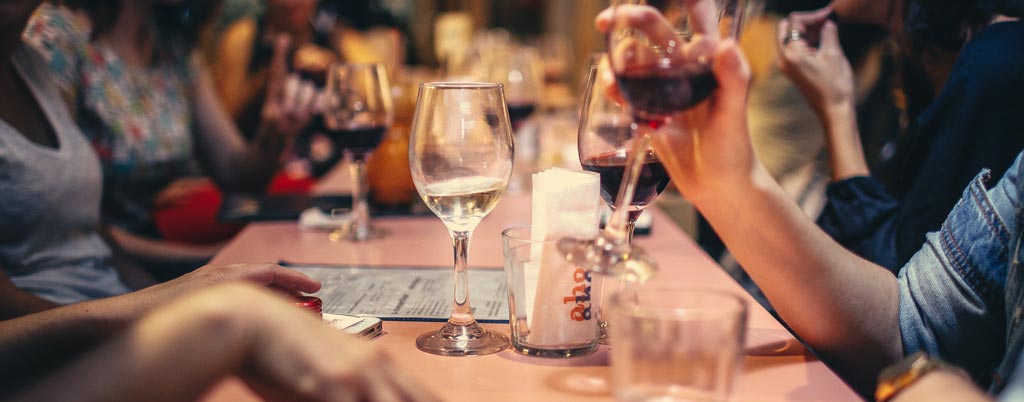 people celebrating and drinking wine in restaurant