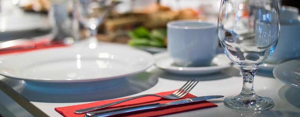 elegant place setting with red knapkin and white table cloth